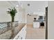 Spacious kitchen with white cabinets, granite countertops, mosaic backsplash, and stainless steel appliances at 5800 Spruce Creek Woods Dr, Port Orange, FL 32127