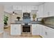 Updated kitchen showcases white cabinetry, granite countertops, stainless steel appliances, and mosaic backsplash at 5800 Spruce Creek Woods Dr, Port Orange, FL 32127