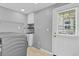 Functional laundry room with modern appliances, sink, storage, and convenient access to the outside at 5800 Spruce Creek Woods Dr, Port Orange, FL 32127
