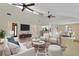 Staged open concept living room with high ceilings, tile floors, skylights, and neutral colors at 5800 Spruce Creek Woods Dr, Port Orange, FL 32127