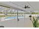 Screened in pool with a ceiling fan and nice landscaping offers a refreshing outdoor retreat at 5800 Spruce Creek Woods Dr, Port Orange, FL 32127