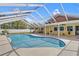 Inviting pool with screened enclosure and yellow home exterior under a bright blue sky at 5800 Spruce Creek Woods Dr, Port Orange, FL 32127