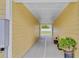 Covered walkway lined with potted plants, providing a charming transition between spaces at 5800 Spruce Creek Woods Dr, Port Orange, FL 32127