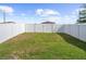 A fenced-in backyard with a well maintained lawn and a gated entrance at the end at 597 Madison Dr, Davenport, FL 33837