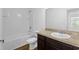 Bathroom with white walls, modern vanity with solid surface top, and shower-tub combo at 597 Madison Dr, Davenport, FL 33837