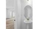 Well-lit bathroom with a stylish pedestal sink, oval mirror and views to the living room and backyard at 597 Madison Dr, Davenport, FL 33837
