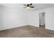 Carpeted bedroom with white walls, ceiling fan, and an ensuite bathroom entrance at 597 Madison Dr, Davenport, FL 33837