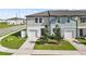 Modern townhome with attached garage, well-manicured lawn, and vibrant landscaping at 597 Madison Dr, Davenport, FL 33837