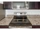 Close up of modern kitchen stove with granite countertops at 597 Madison Dr, Davenport, FL 33837