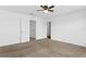 Bright carpeted main bedroom features ensuite bathroom entrance, ceiling fan, and white walls at 597 Madison Dr, Davenport, FL 33837