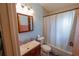 Bathroom featuring a wooden vanity, toilet, mirror, and shower with a white curtain at 620 E Church Ave, Longwood, FL 32750