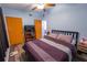 Bedroom features a queen bed, a television on a wooden shelf, and 2 doors at 620 E Church Ave, Longwood, FL 32750