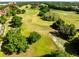 Sweeping aerial view of a lush green golf course surrounded by mature trees at 6685 Queens Borough Ave # 202, Orlando, FL 32835