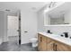A bathroom features a double sink vanity, an illuminated mirror, and tile floors at 6685 Queens Borough Ave # 202, Orlando, FL 32835