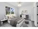 Airy bedroom features a large window overlooking greenery and modern decor and furnishings at 6685 Queens Borough Ave # 202, Orlando, FL 32835