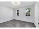 A bright bedroom featuring two windows and hardwood style floors at 6685 Queens Borough Ave # 202, Orlando, FL 32835