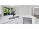 Well-lit kitchen with white cabinetry, a stainless-steel dishwasher, and a garden view at 6685 Queens Borough Ave # 202, Orlando, FL 32835