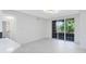 Bright, open living room with white tile floors and sliding glass doors to a balcony at 6685 Queens Borough Ave # 202, Orlando, FL 32835