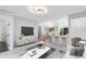 Bright, open-concept living room featuring modern furnishings and sleek lighting fixtures at 6685 Queens Borough Ave # 202, Orlando, FL 32835