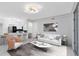 Modern living room with stylish decor, white sofa, and a view of the kitchen area at 6685 Queens Borough Ave # 202, Orlando, FL 32835