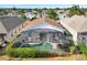 Backyard aerial view showcasing a screened-in pool, lush landscaping, and a well-maintained shingle roof at 8118 Fan Palm Way, Kissimmee, FL 34747