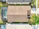 Birds-eye view of a home with a private screened-in pool, landscaped backyard, and a shingle roof at 8118 Fan Palm Way, Kissimmee, FL 34747