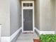 Stylish front door with secure lock, a charming welcome mat, and neat landscaping for a warm, inviting entrance at 8118 Fan Palm Way, Kissimmee, FL 34747