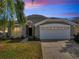 Charming single-story home featuring a well-manicured lawn, mature palm tree, and a two-car garage, showcasing curb appeal at 8118 Fan Palm Way, Kissimmee, FL 34747