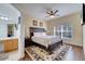 Cozy bedroom showcasing a ceiling fan, rug, hardwood floors, with an attached bathroom at 8118 Fan Palm Way, Kissimmee, FL 34747