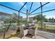 Relax on the screened-in patio with table and chairs, creating an inviting outdoor space at 8118 Fan Palm Way, Kissimmee, FL 34747