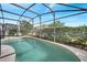 Inviting screened-in pool area with outdoor seating and privacy landscaping at 8118 Fan Palm Way, Kissimmee, FL 34747