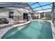Screened-in backyard pool with a safety fence and covered seating area at 8118 Fan Palm Way, Kissimmee, FL 34747
