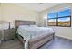 Comfortable bedroom featuring a rustic wood bed frame and large window with beautiful exterior view at 9044 Azalea Sands Ln # 4011, Davenport, FL 33896