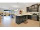 Open concept kitchen with dark cabinetry, stainless steel appliances, quartz countertops, and seamlessly flowing to living area at 9044 Azalea Sands Ln # 4011, Davenport, FL 33896