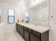 Well-lit bathroom with double sinks, a large mirror and a sleek design that offer both style and functionality at 9188 Chandler Dr, Groveland, FL 34736