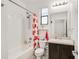 A bathroom features a shower-tub combo, decorative shower curtain, and a vanity with storage at 9188 Chandler Dr, Groveland, FL 34736