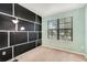 A stylish bedroom with teal walls and a black accent wall with a large window at 9188 Chandler Dr, Groveland, FL 34736