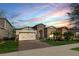 Charming single-Gathering home featuring a brick driveway, manicured lawn, and stone accents, all under a beautiful sky at 9188 Chandler Dr, Groveland, FL 34736