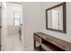 Inviting hallway with stylish furniture, a modern mirror, and a glimpse into the laundry room at 9188 Chandler Dr, Groveland, FL 34736