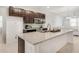 Modern kitchen featuring dark wood cabinets, stainless steel appliances, granite countertops, and an open layout at 9188 Chandler Dr, Groveland, FL 34736
