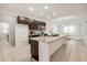 Stylish kitchen boasts dark wood cabinetry, stainless steel appliances, granite counters, and an island with a sink at 9188 Chandler Dr, Groveland, FL 34736