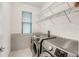 Well-equipped laundry room with modern machines, storage shelves, and a practical design at 9188 Chandler Dr, Groveland, FL 34736