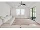 Cozy living room featuring a white sectional sofa, tray ceilings, large windows, and sliding glass doors for ample light at 9188 Chandler Dr, Groveland, FL 34736