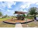 Community playground featuring modern equipment, a shaded canopy, and a safe play surface at 9188 Chandler Dr, Groveland, FL 34736
