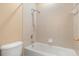 Bathroom featuring a shower over tub with a showerhead, toilet, and tile walls at 9469 Edenshire Cir, Orlando, FL 32836