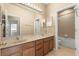 Bright bathroom with tile flooring, double sinks, large mirror and ample lighting at 9469 Edenshire Cir, Orlando, FL 32836
