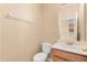Well-lit half bathroom featuring a toilet, sink with vanity, mirror, and towel rack at 9469 Edenshire Cir, Orlando, FL 32836