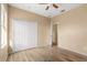Bedroom featuring wood floors, ceiling fan, closet with white doors and neutral walls at 9469 Edenshire Cir, Orlando, FL 32836