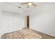 Bedroom featuring wood-look flooring, a ceiling fan, closet and a glimpse into another room at 9469 Edenshire Cir, Orlando, FL 32836
