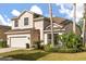 Two story home with manicured garden, palm trees and a two car garage, perfect for a Gathering at 9469 Edenshire Cir, Orlando, FL 32836